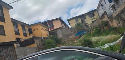 A Vacant Plot of Land, Fenced and Gated on a Tarred Street